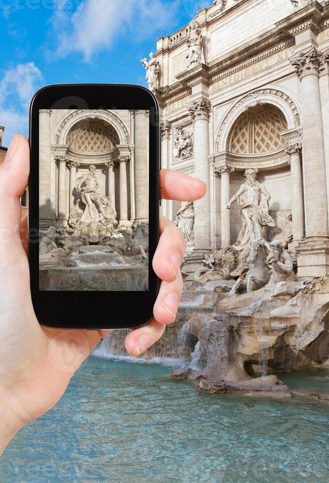 turista tomando fotos de la fuente de trevi en roma