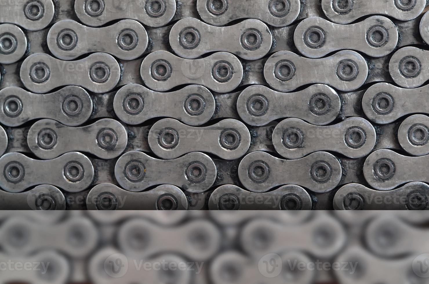 Dirty and oily chain from a mountain bike lying on a wooden table in a bicycle shop photo