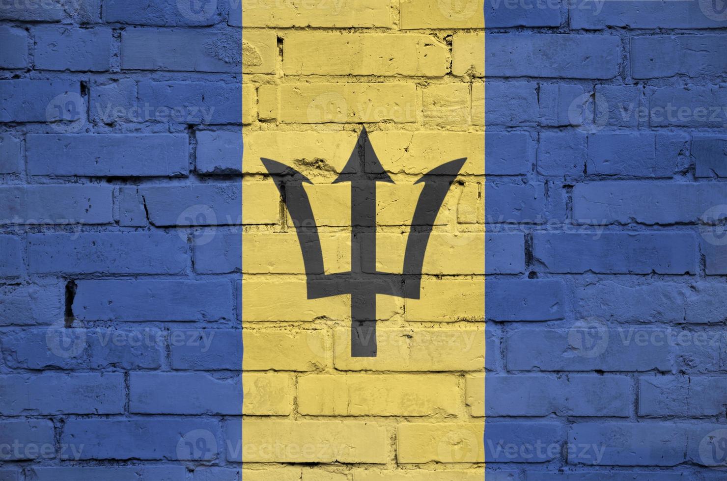 Barbados flag is painted onto an old brick wall photo