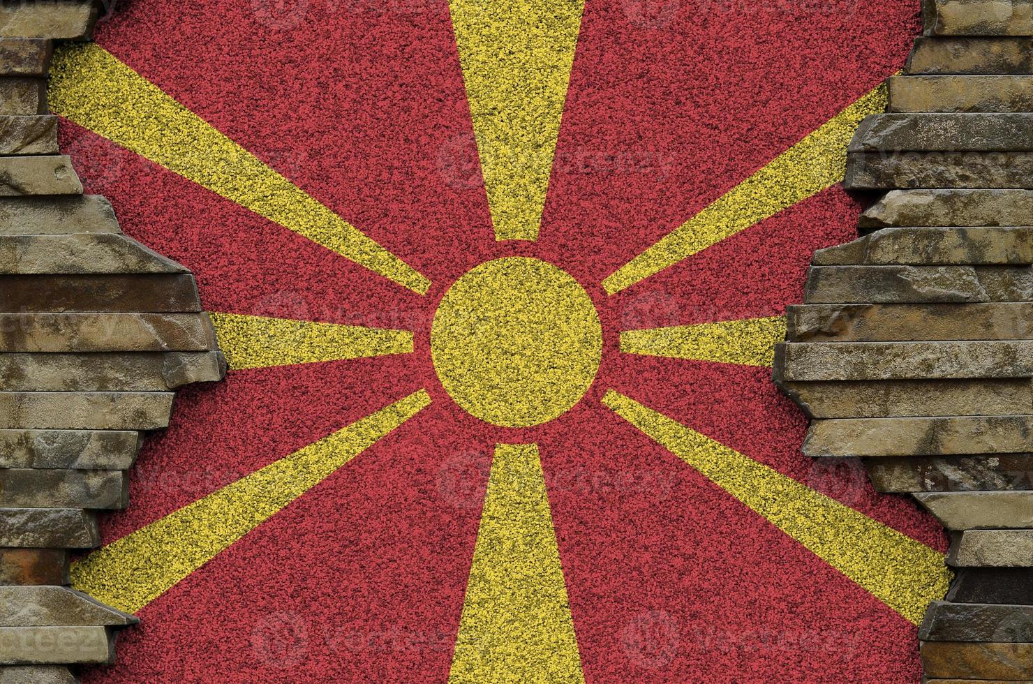 Macedonia flag depicted in paint colors on old stone wall closeup. Textured banner on rock wall background photo