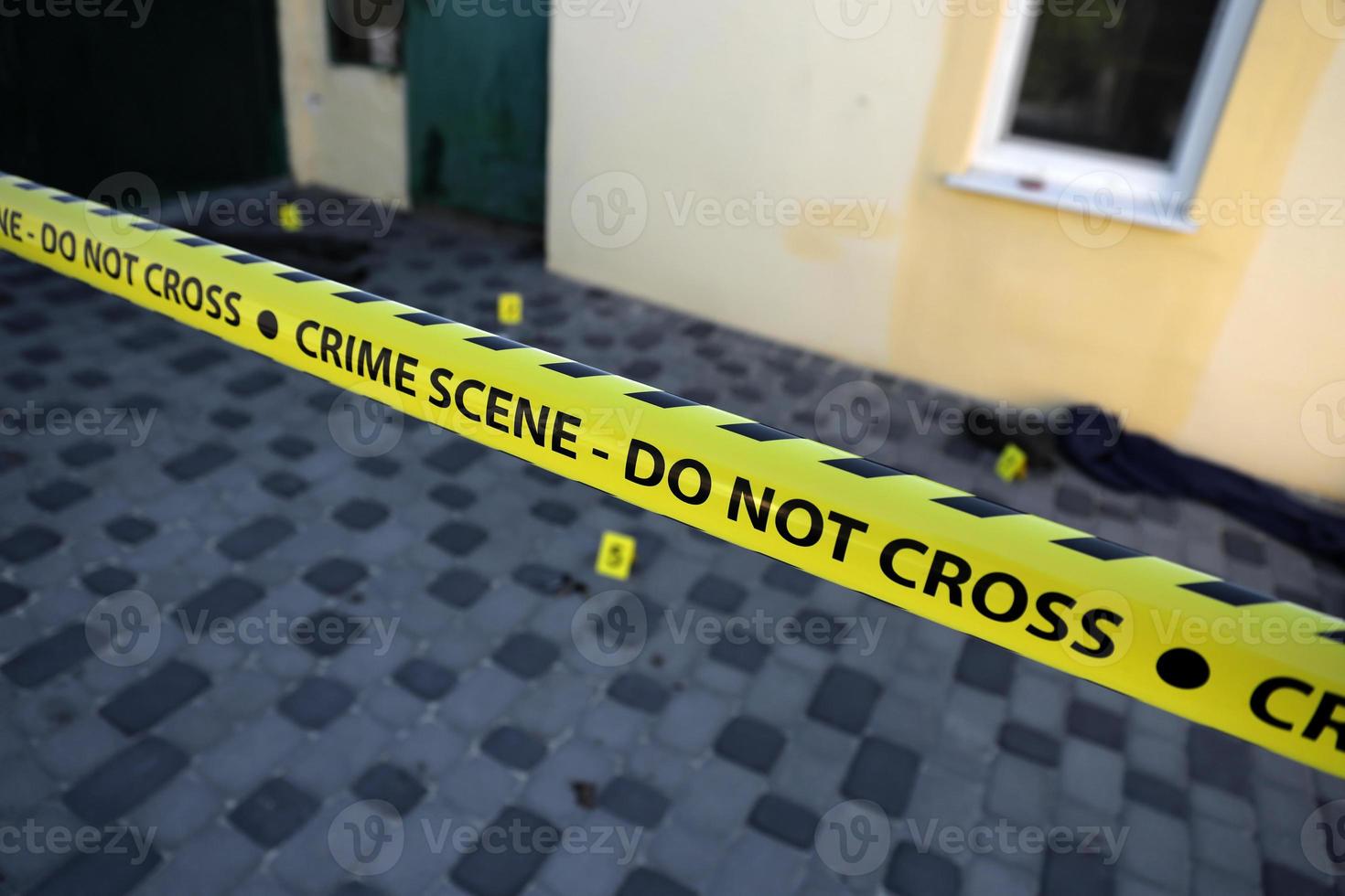 Crime scene tape for covering the area cordon. Yellow tape with blurred forensic law enforcement background in cinematic tone photo