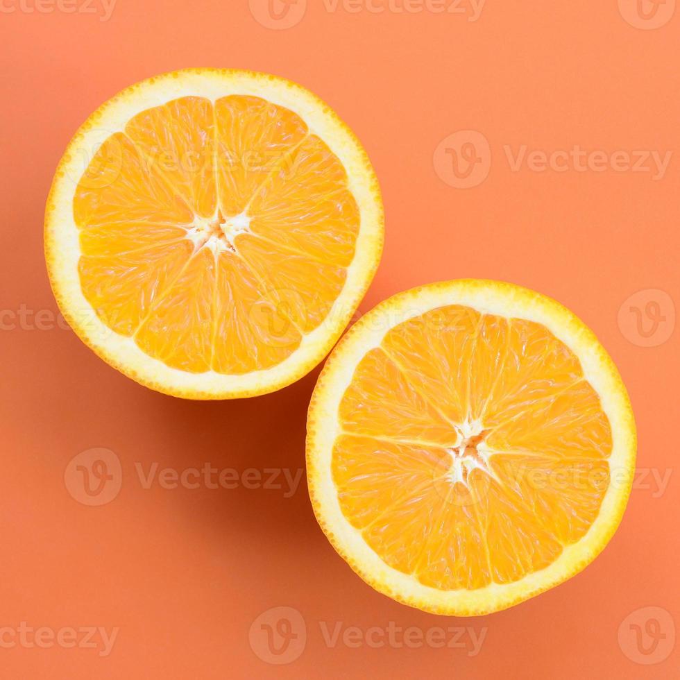 Top view of a several orange fruit slices on bright background in orange color. A saturated citrus texture image photo