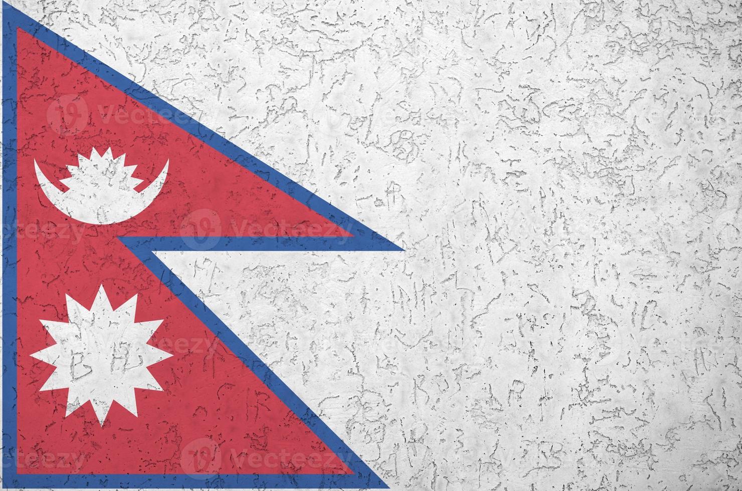 Nepal flag depicted in bright paint colors on old relief plastering wall. Textured banner on rough background photo
