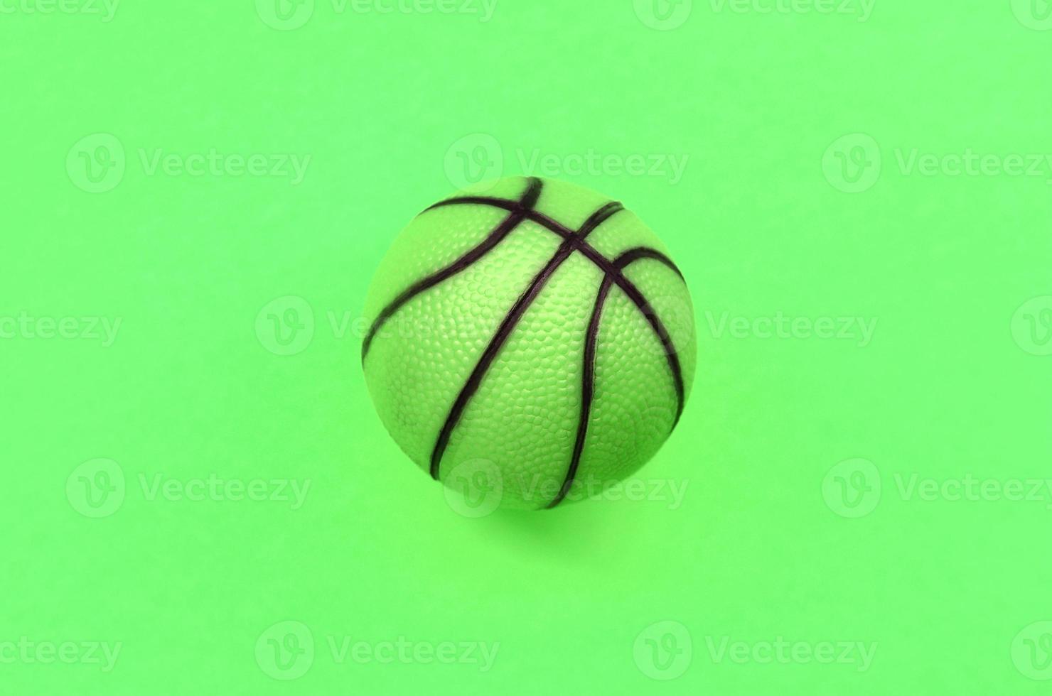 Small green ball for basketball sport game lies on texture background photo