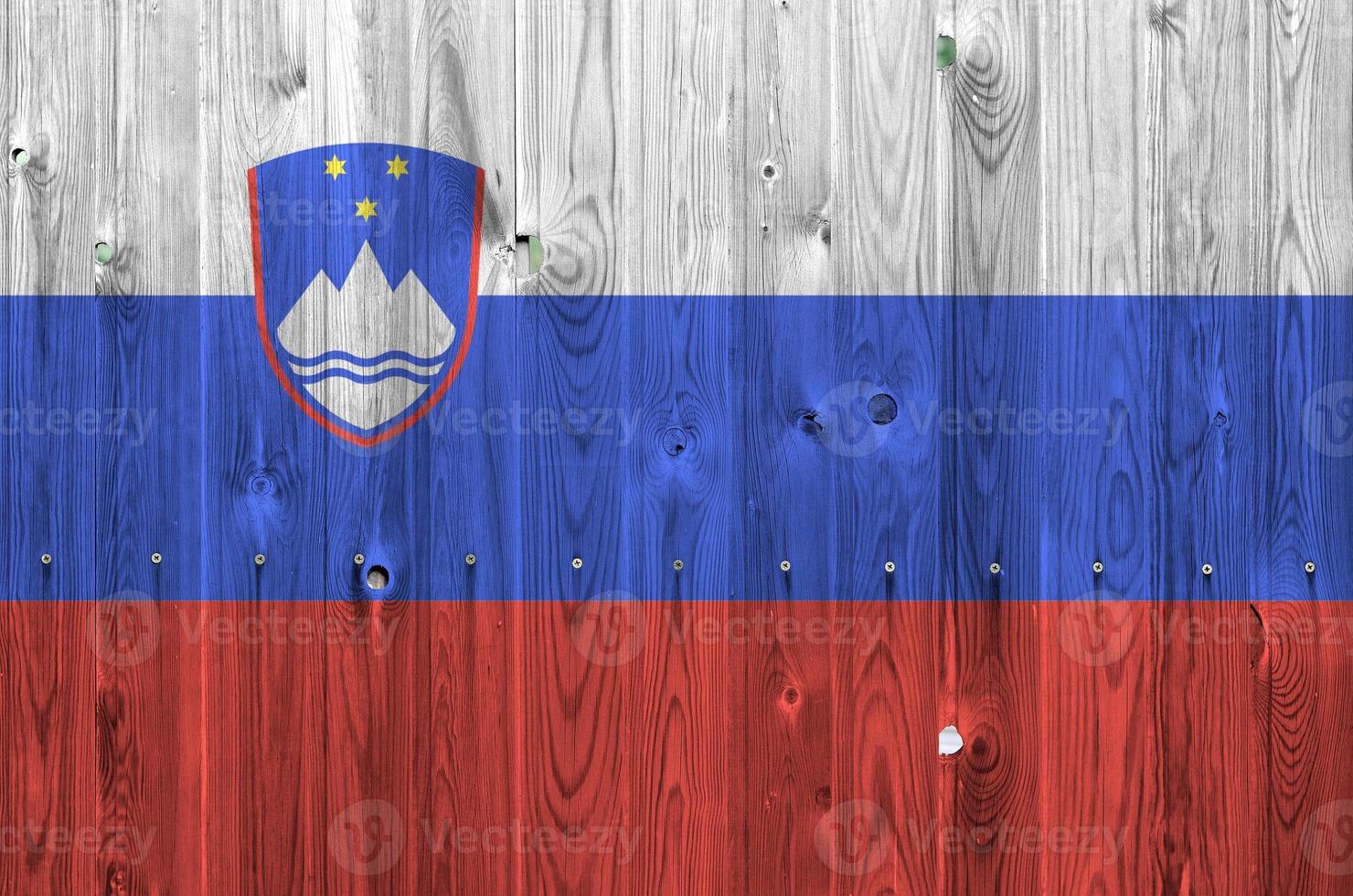 Slovenia flag depicted in bright paint colors on old wooden wall. Textured banner on rough background photo