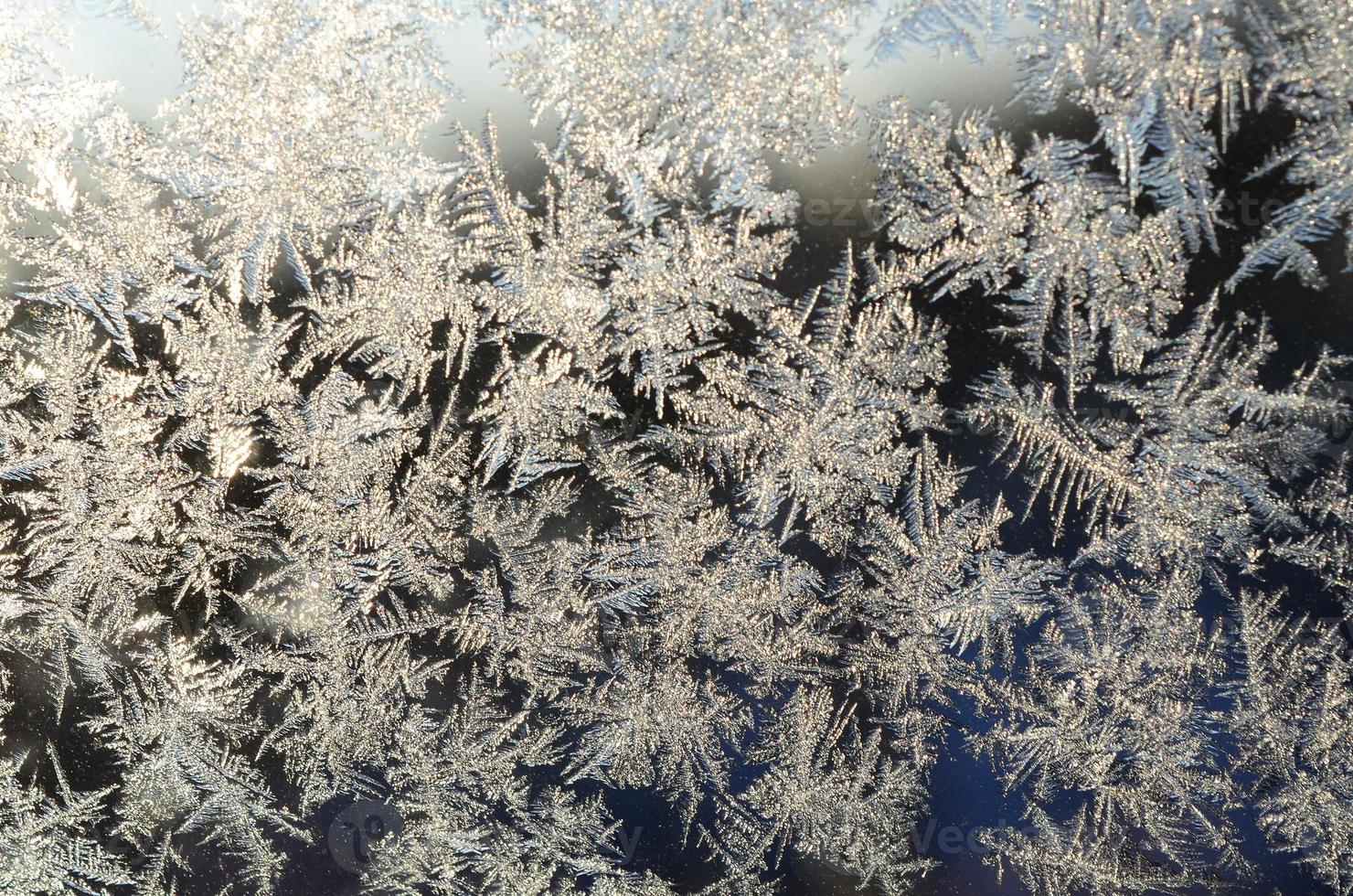 Snowflakes frost rime macro on window glass pane photo