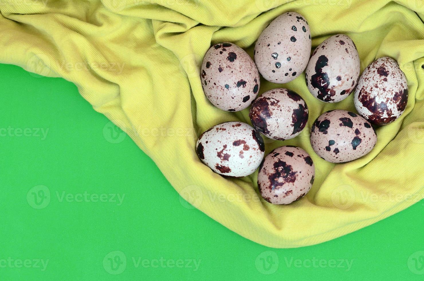 Quail eggs on a light green surface, top view, empty place for t photo