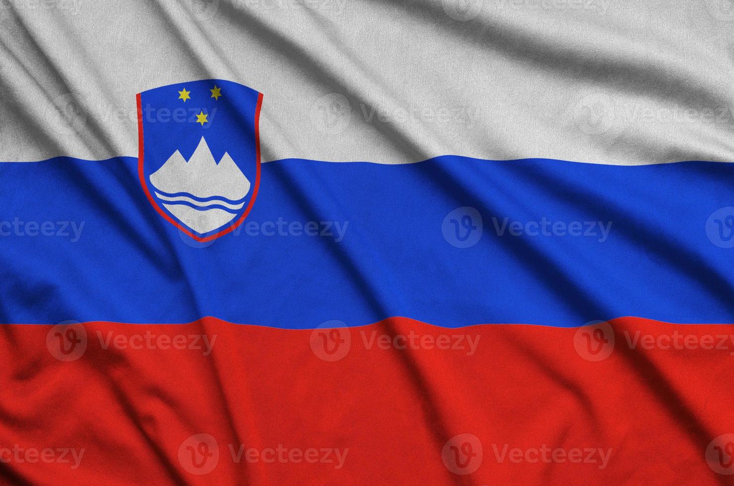 Slovenia flag  is depicted on a sports cloth fabric with many folds. Sport team banner photo
