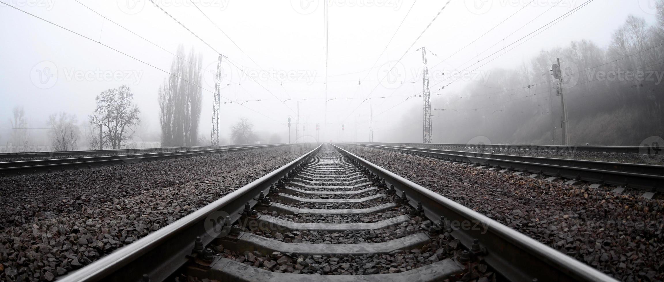 The railway track in a misty morning. A lot of rails and sleepers go into the misty horizon. Fisheye photo with increased distortion