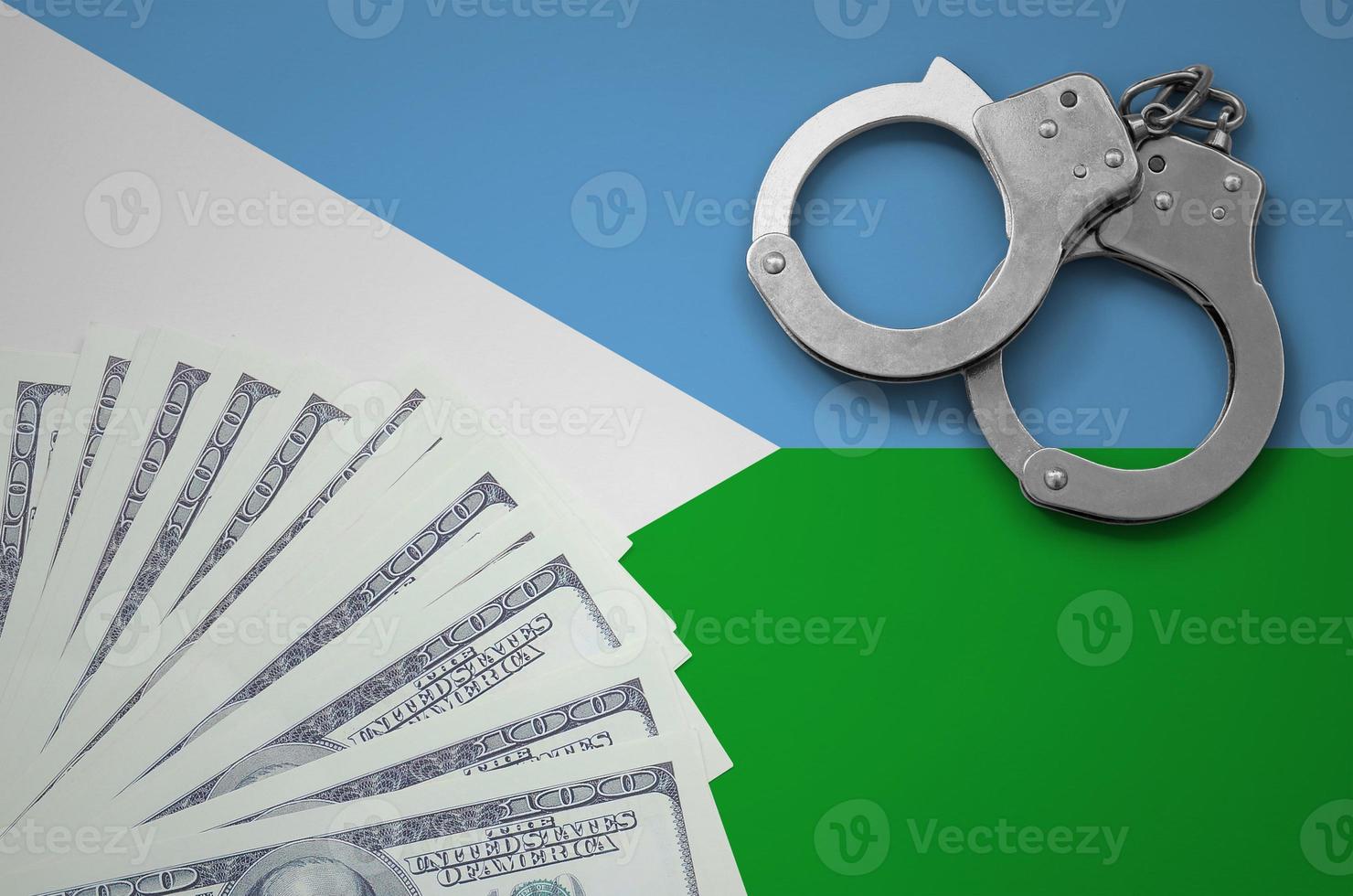 Djibouti flag  with handcuffs and a bundle of dollars. The concept of illegal banking operations in US currency photo