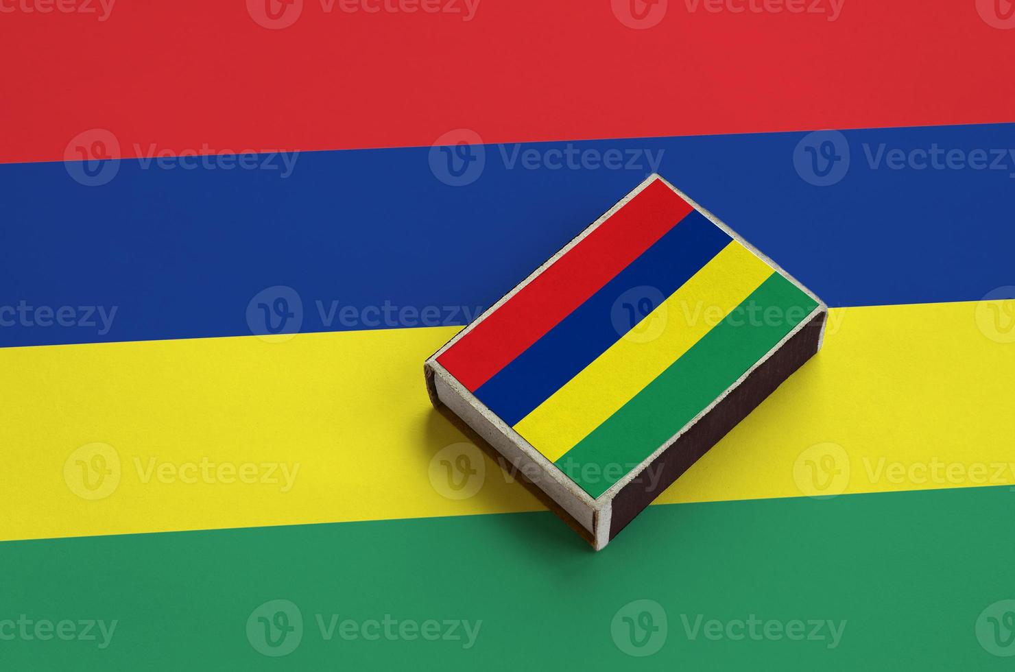 Mauritius flag  is pictured on a matchbox that lies on a large flag photo
