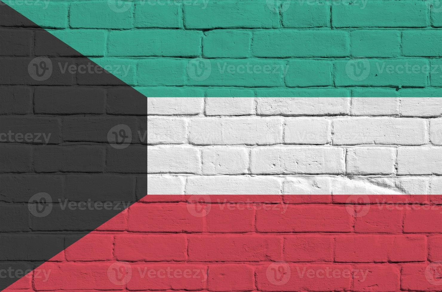 Kuwait flag depicted in paint colors on old brick wall. Textured banner on big brick wall masonry background photo