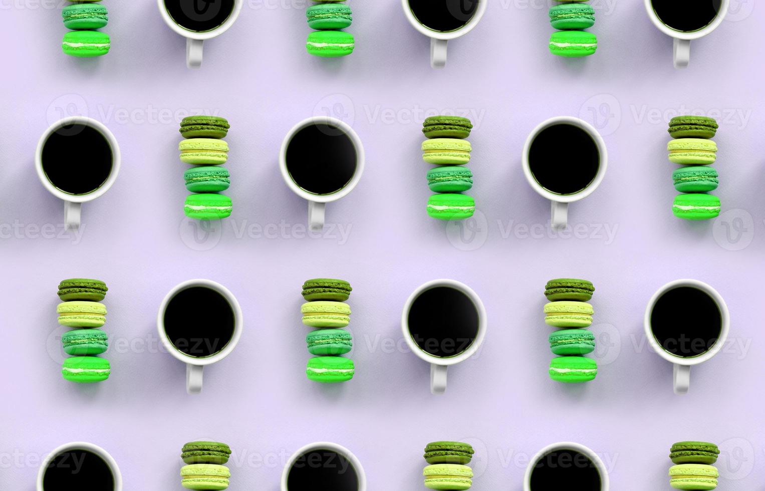 A pattern of many colorful dessert cake macaroon and coffee cups on trendy pastel lilac background top view photo