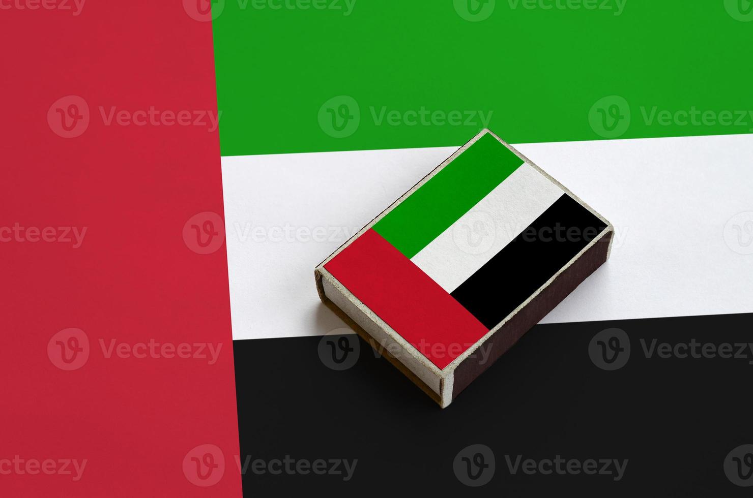 United Arab Emirates flag  is pictured on a matchbox that lies on a large flag photo