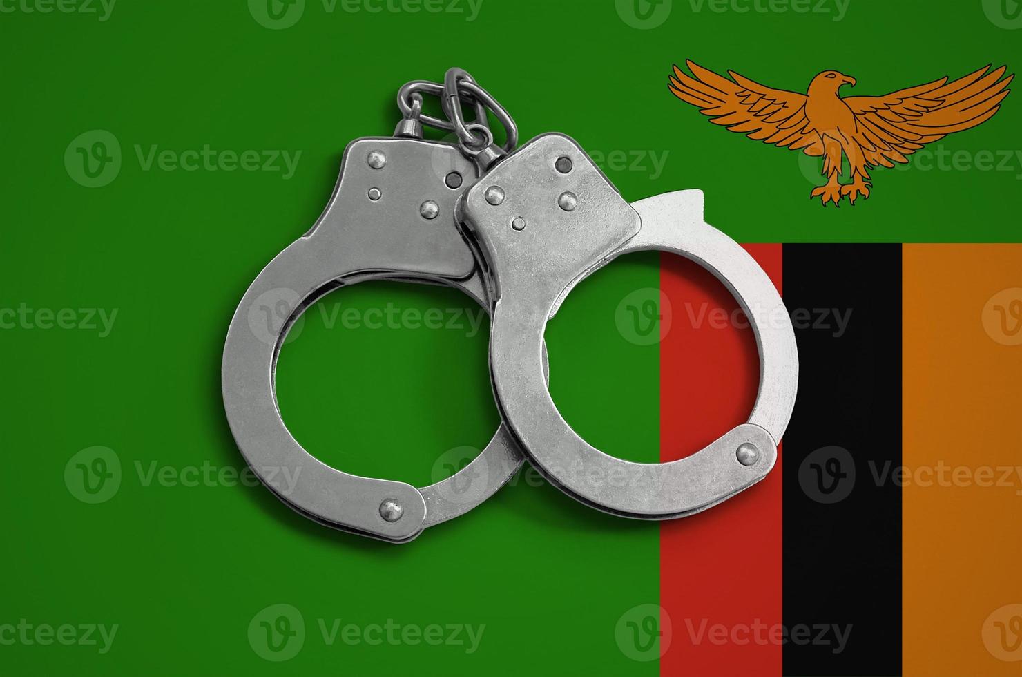 Zambia flag  and police handcuffs. The concept of observance of the law in the country and protection from crime photo