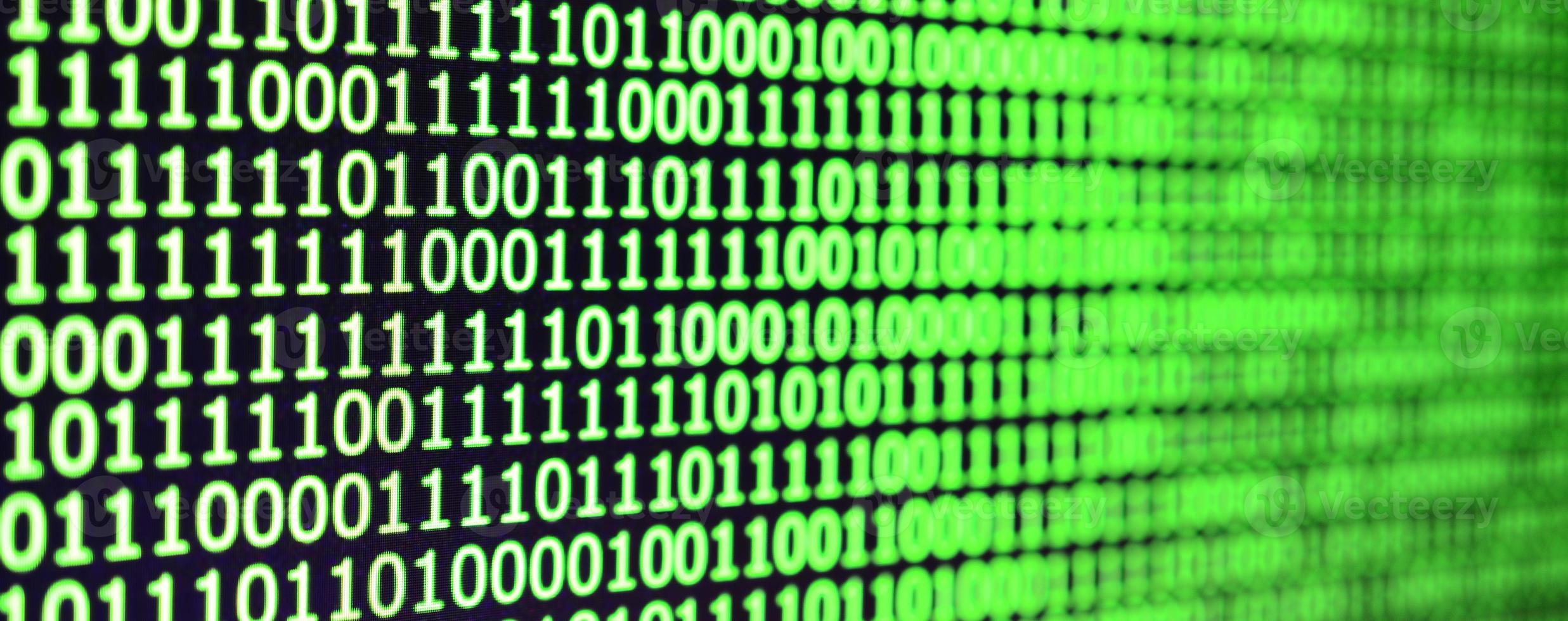 toma macro de código binario en el monitor de una computadora de oficina. el concepto del trabajo del programador. el flujo de cadenas de información digital foto