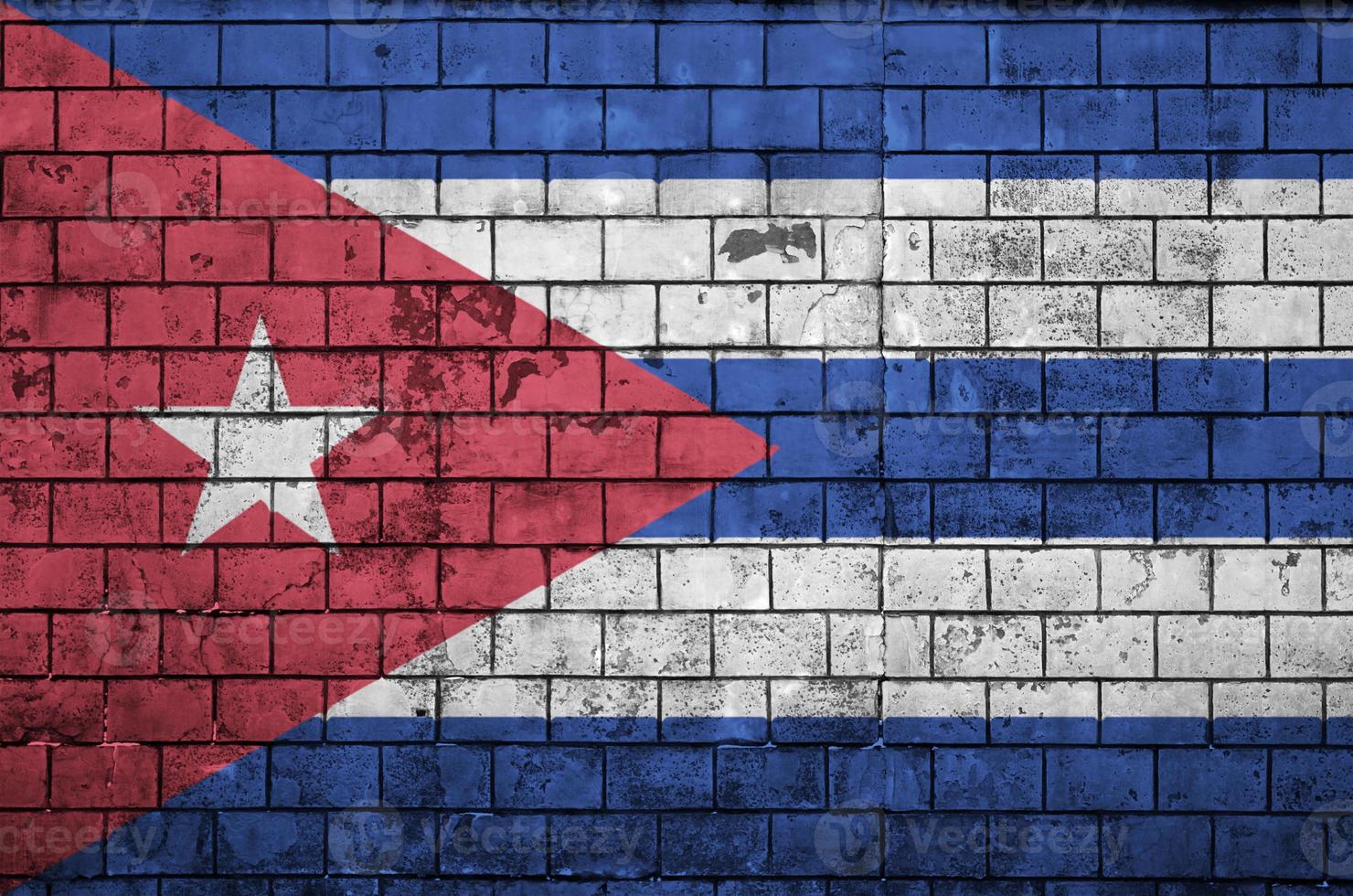 Cuba flag is painted onto an old brick wall photo