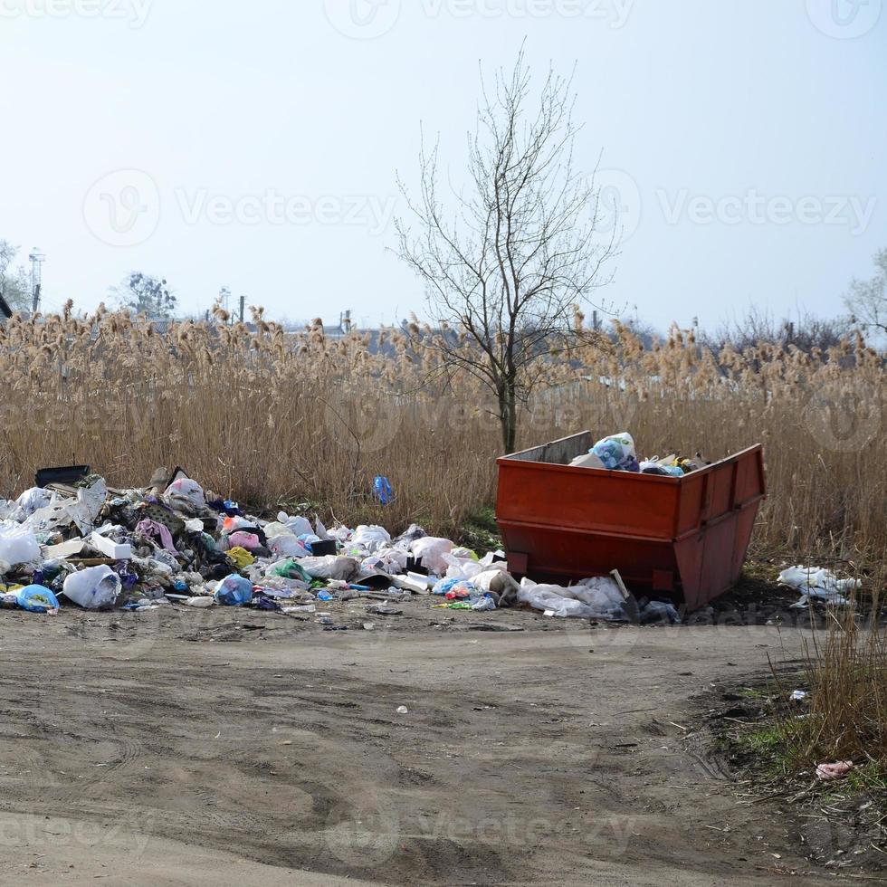 el bote de basura está lleno de basura y desechos. retiro intempestivo de basura en zonas pobladas foto