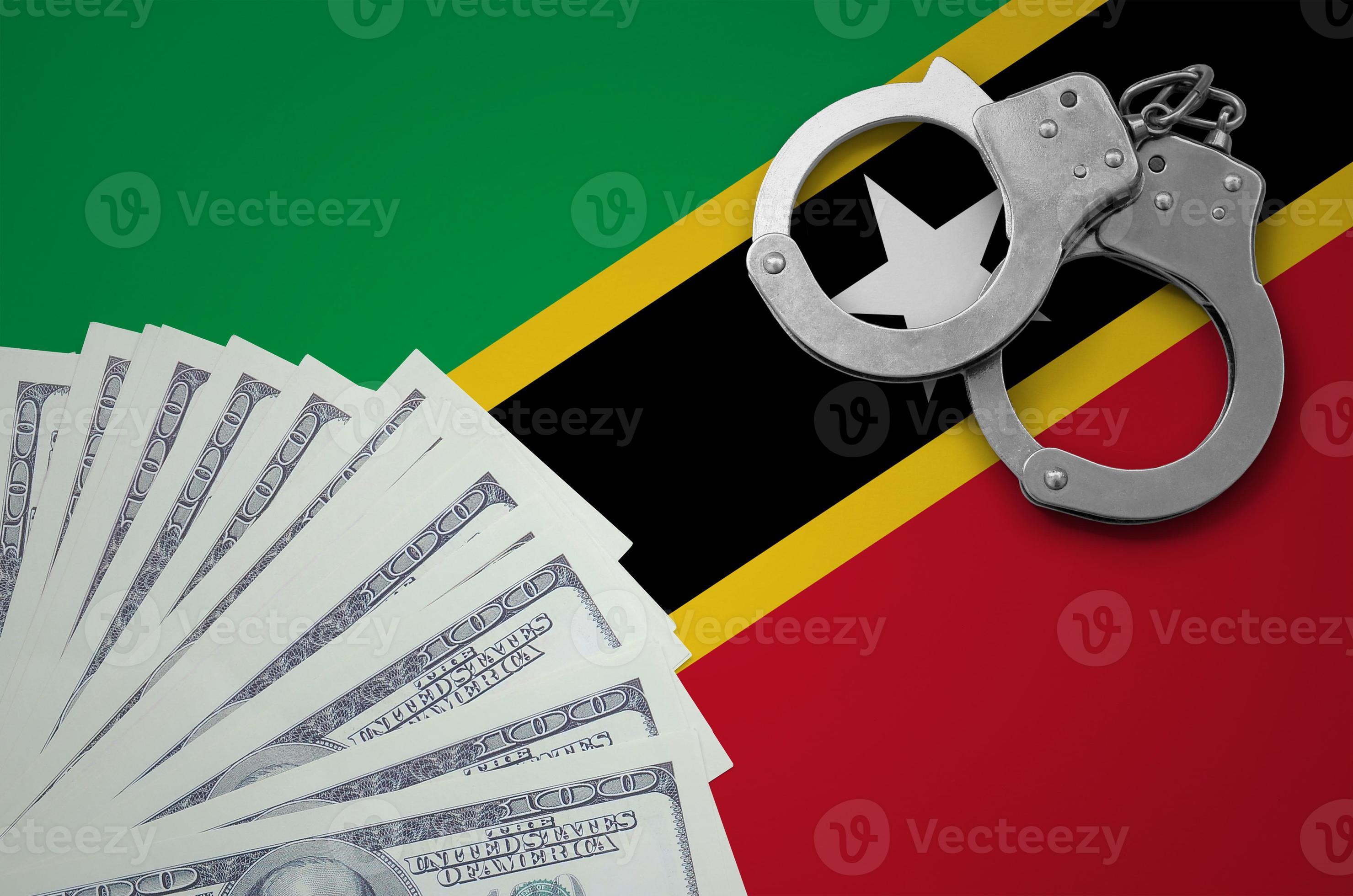 Saint Kitts and Nevis flag with handcuffs and a bundle of dollars. The