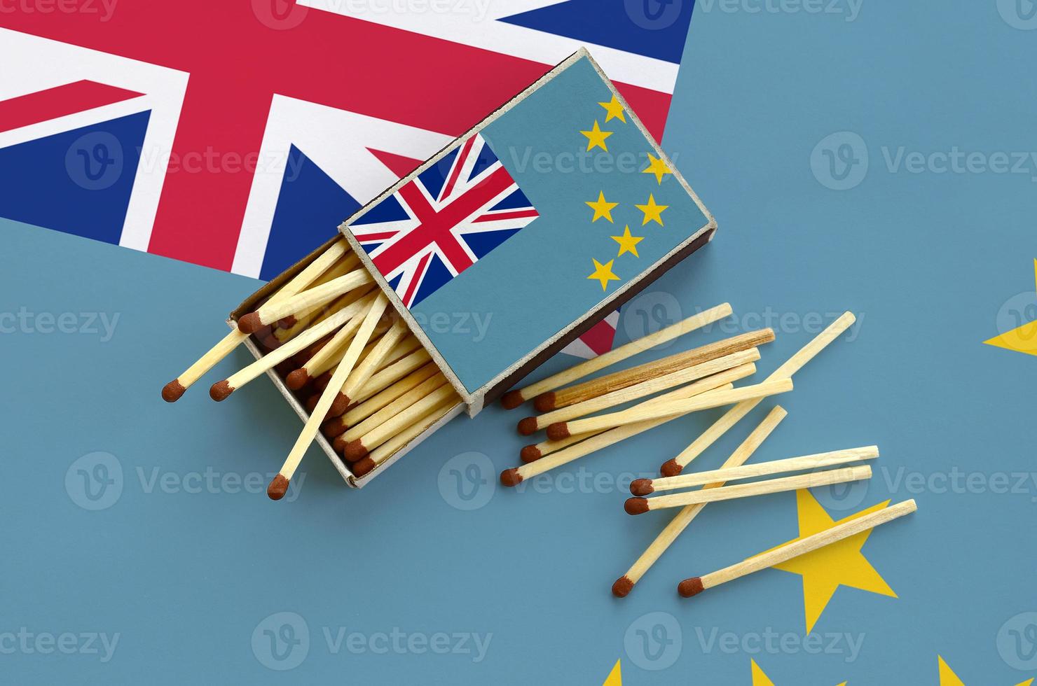 Tuvalu flag  is shown on an open matchbox, from which several matches fall and lies on a large flag photo