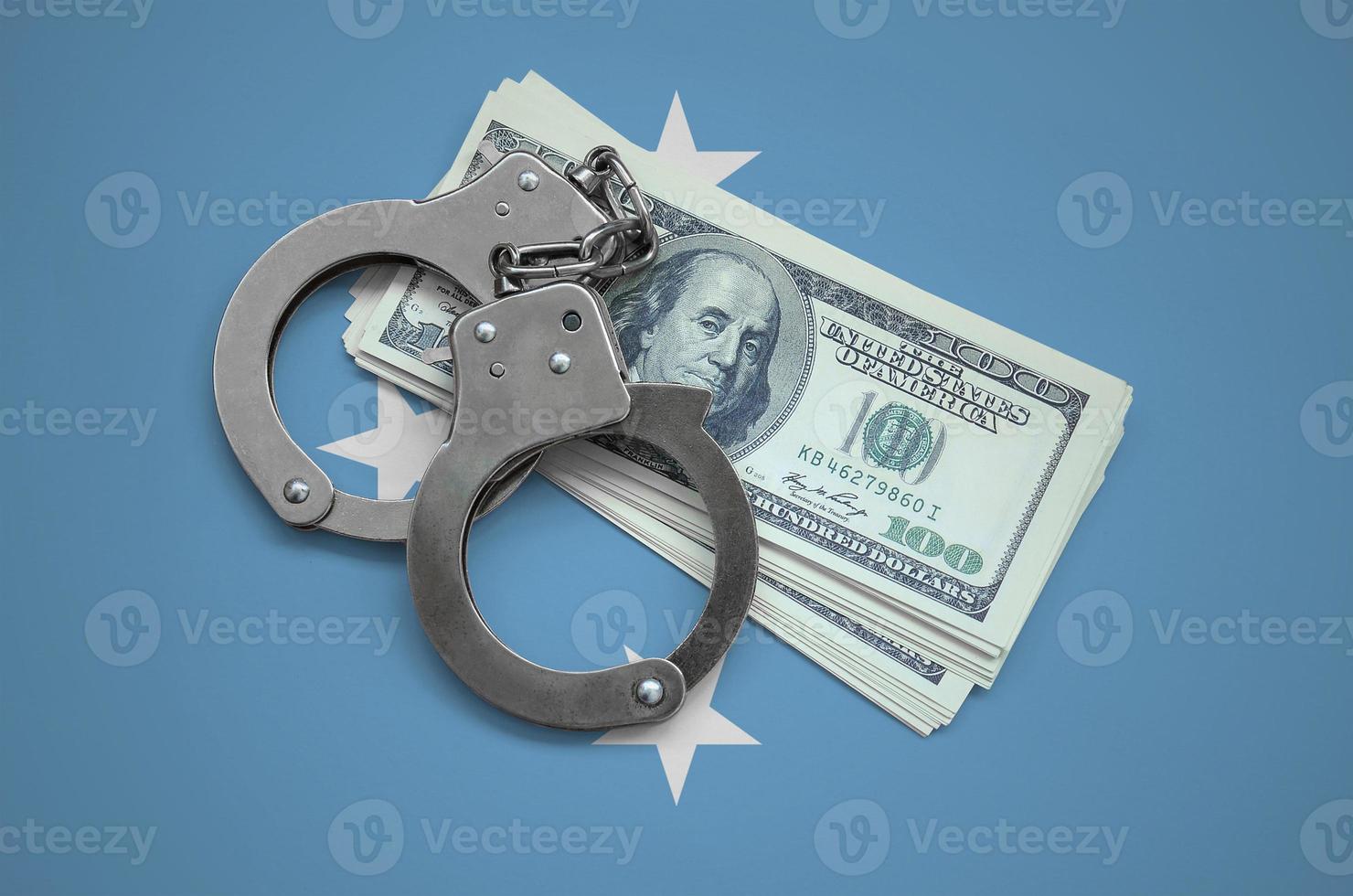 Micronesia flag  with handcuffs and a bundle of dollars. Currency corruption in the country. Financial crimes photo