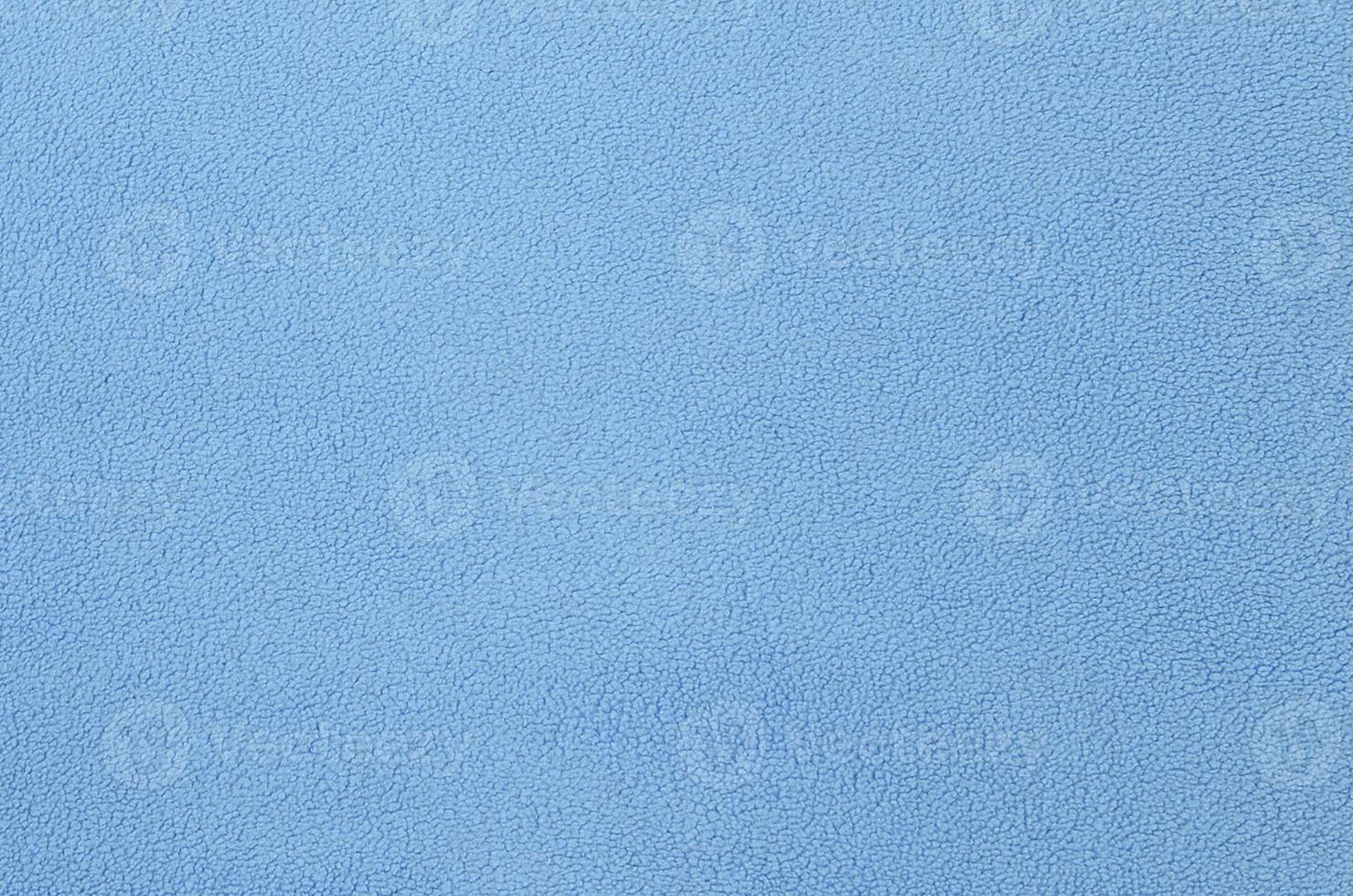The blanket of furry blue fleece fabric. A background texture of light blue soft plush fleece material photo