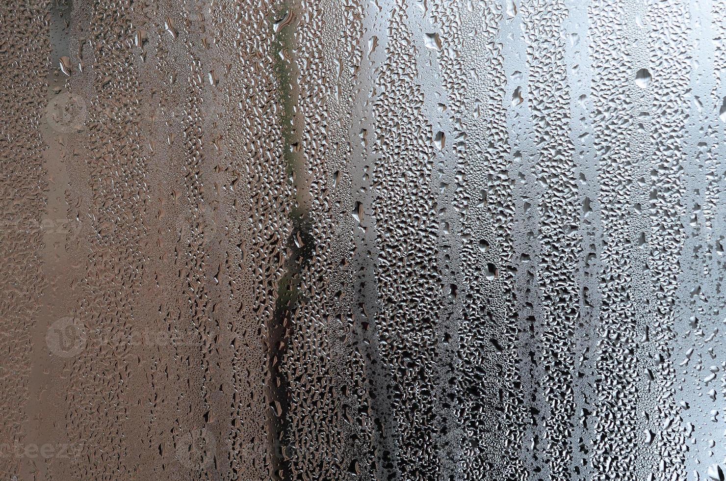 Texture of a drop of rain on a glass wet transparent background. Toned in grey color photo