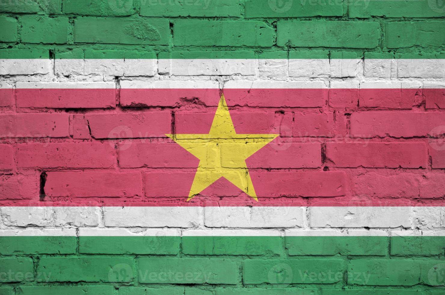 Suriname flag is painted onto an old brick wall photo