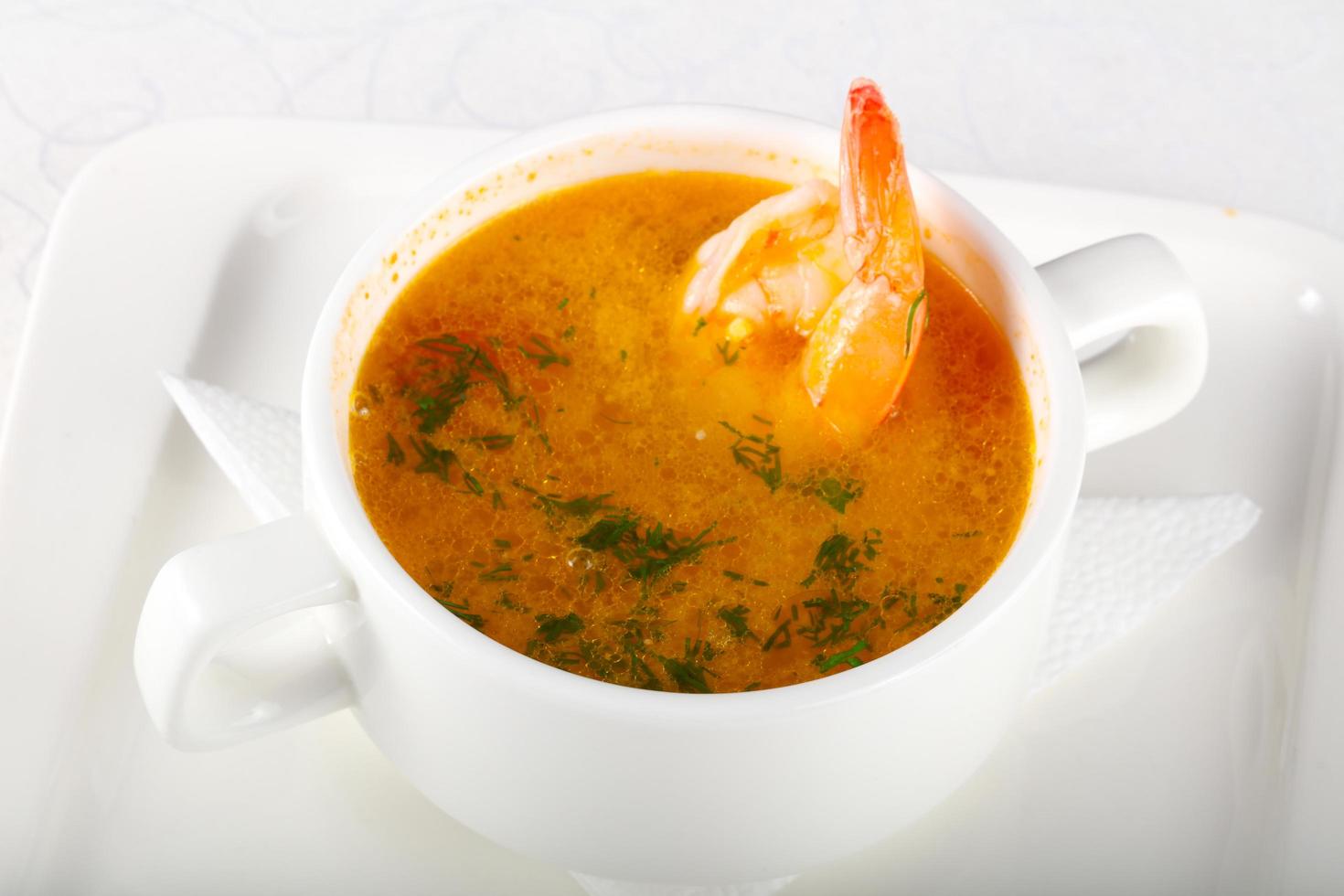 Prawn soup in a bowl on white background photo