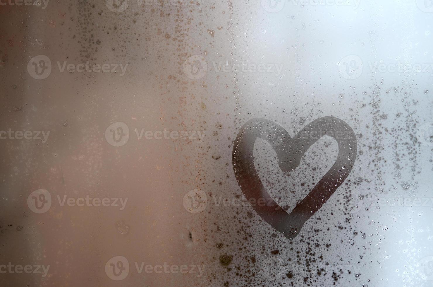 The heart is painted on the misted glass in the winter photo