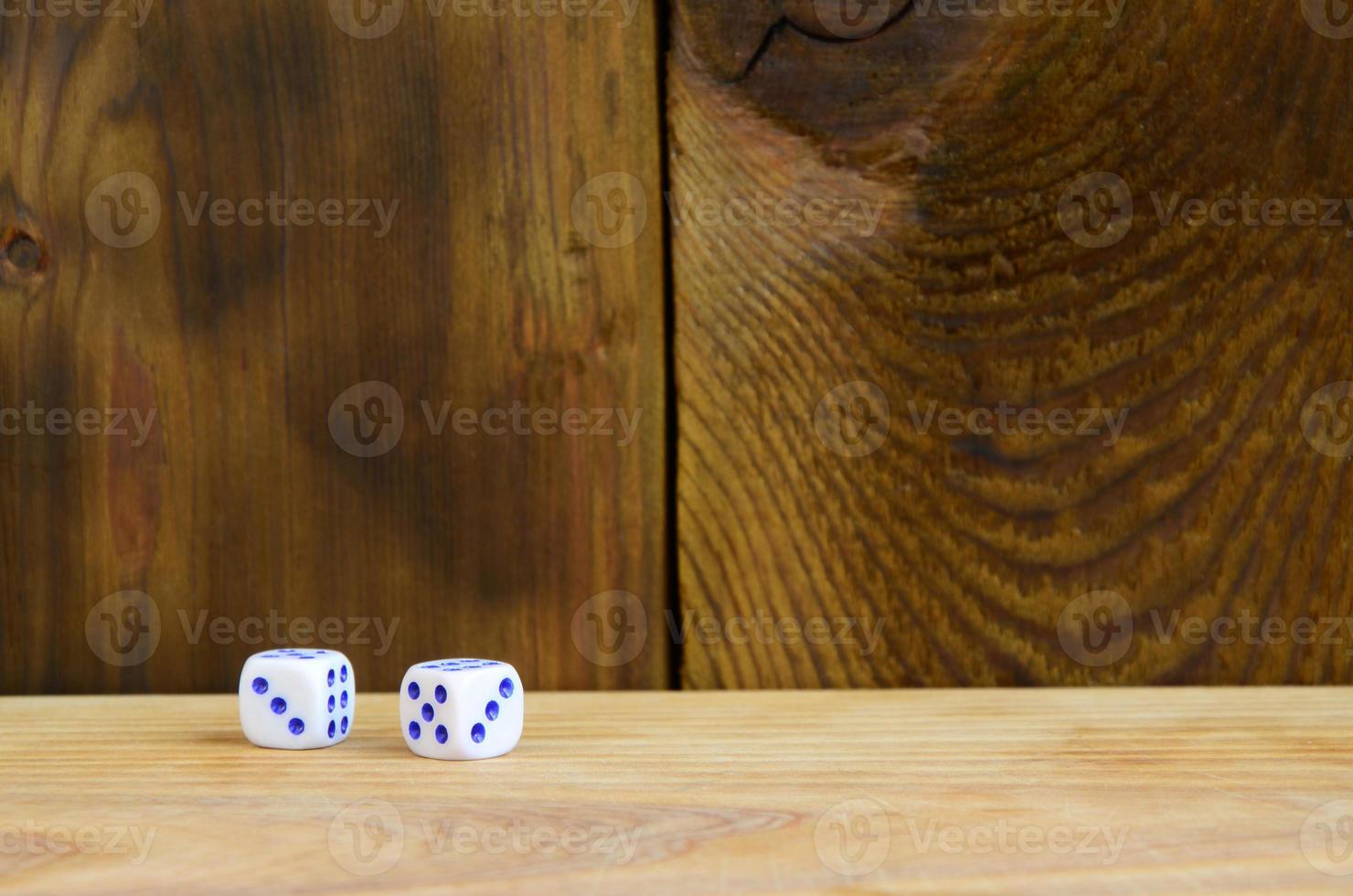 A few dice lies on the surface of natural wood. Items for generating numbers from one to six in the form of points that are painted on the side of cubes. The concept of gambling photo