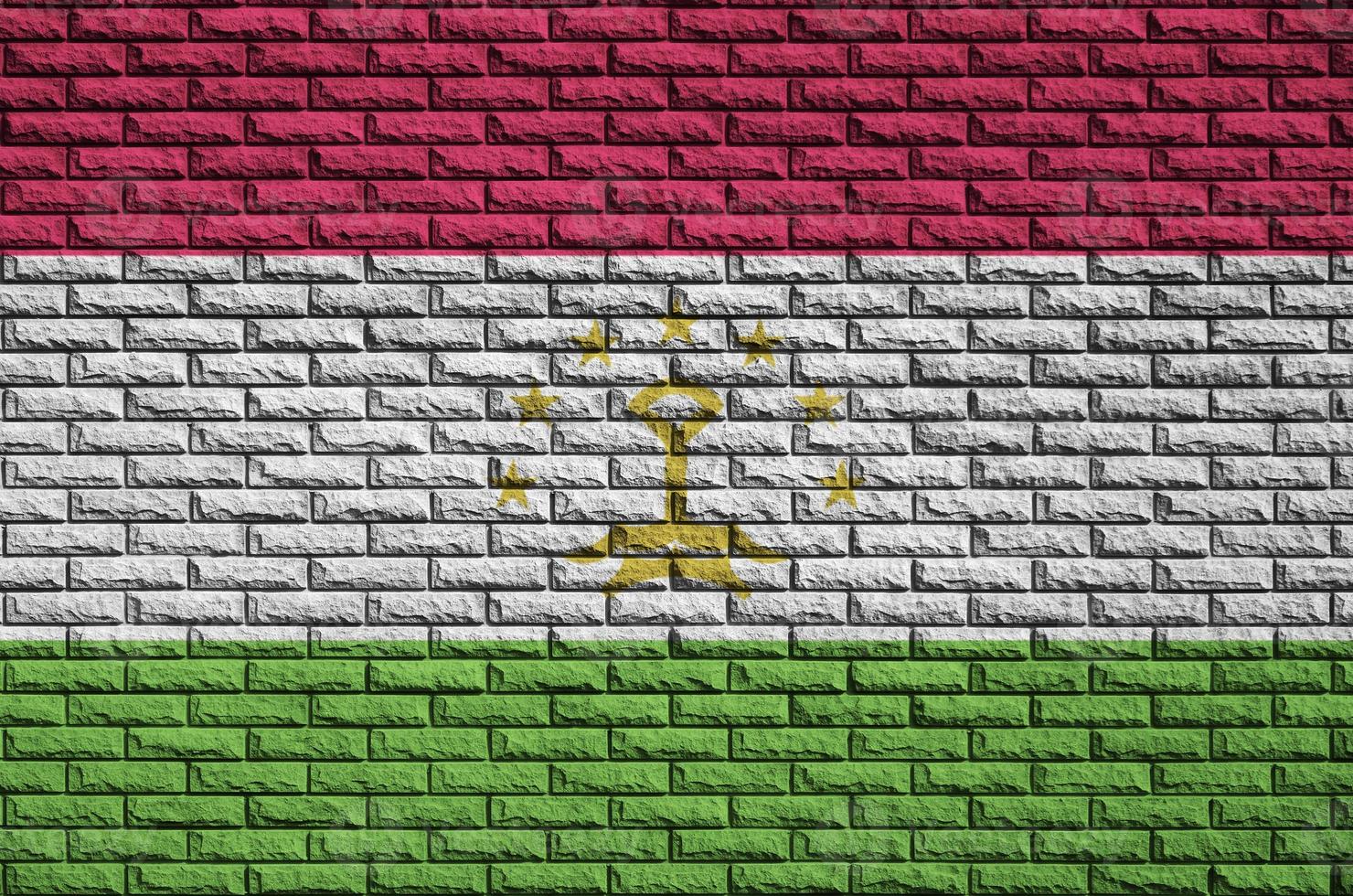 Tajikistan flag is painted onto an old brick wall photo