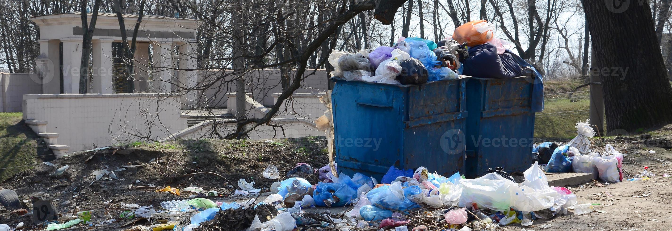 The garbage can is packed with garbage and waste. Untimely removal of garbage in populated areas photo