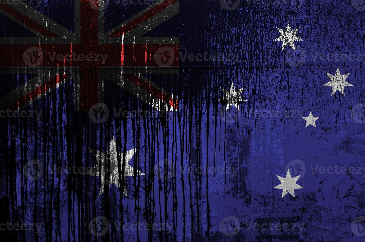 Australia flag depicted in paint colors on old and dirty oil barrel wall closeup. Textured banner on rough background photo