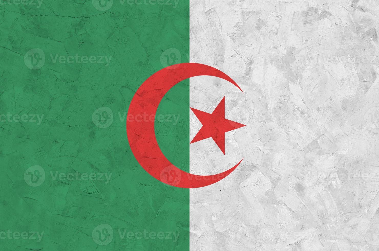 Algeria flag depicted in bright paint colors on old relief plastering wall. Textured banner on rough background photo