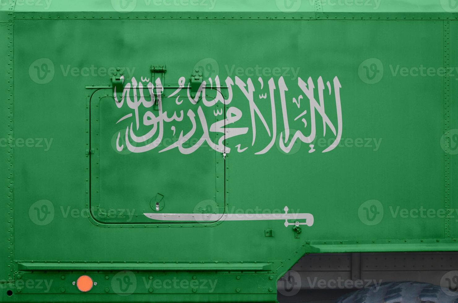 Saudi Arabia flag depicted on side part of military armored truck closeup. Army forces conceptual background photo