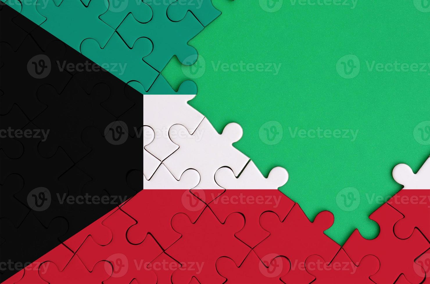 Kuwait flag  is depicted on a completed jigsaw puzzle with free green copy space on the right side photo