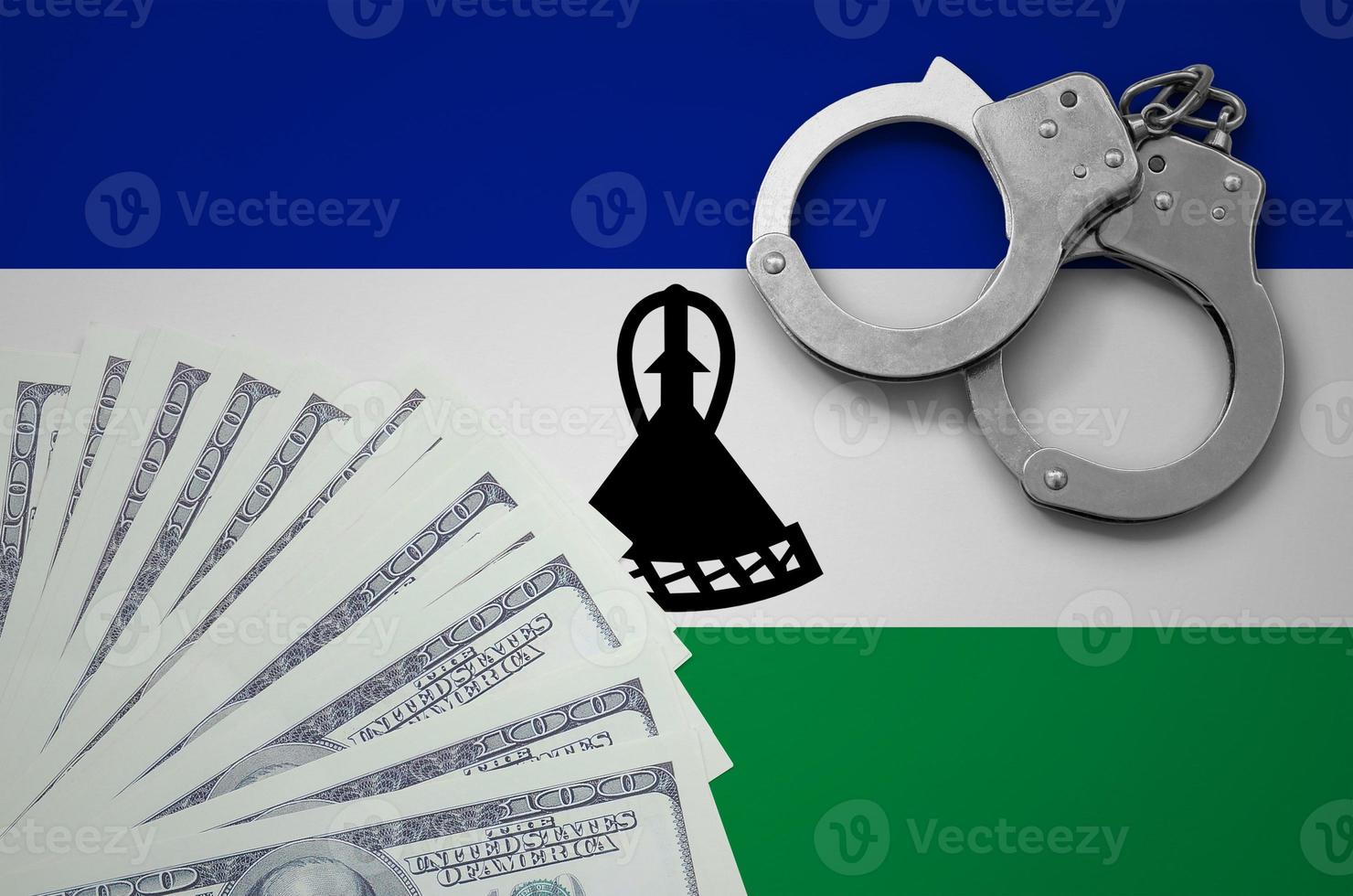 Lesotho flag  with handcuffs and a bundle of dollars. The concept of illegal banking operations in US currency photo