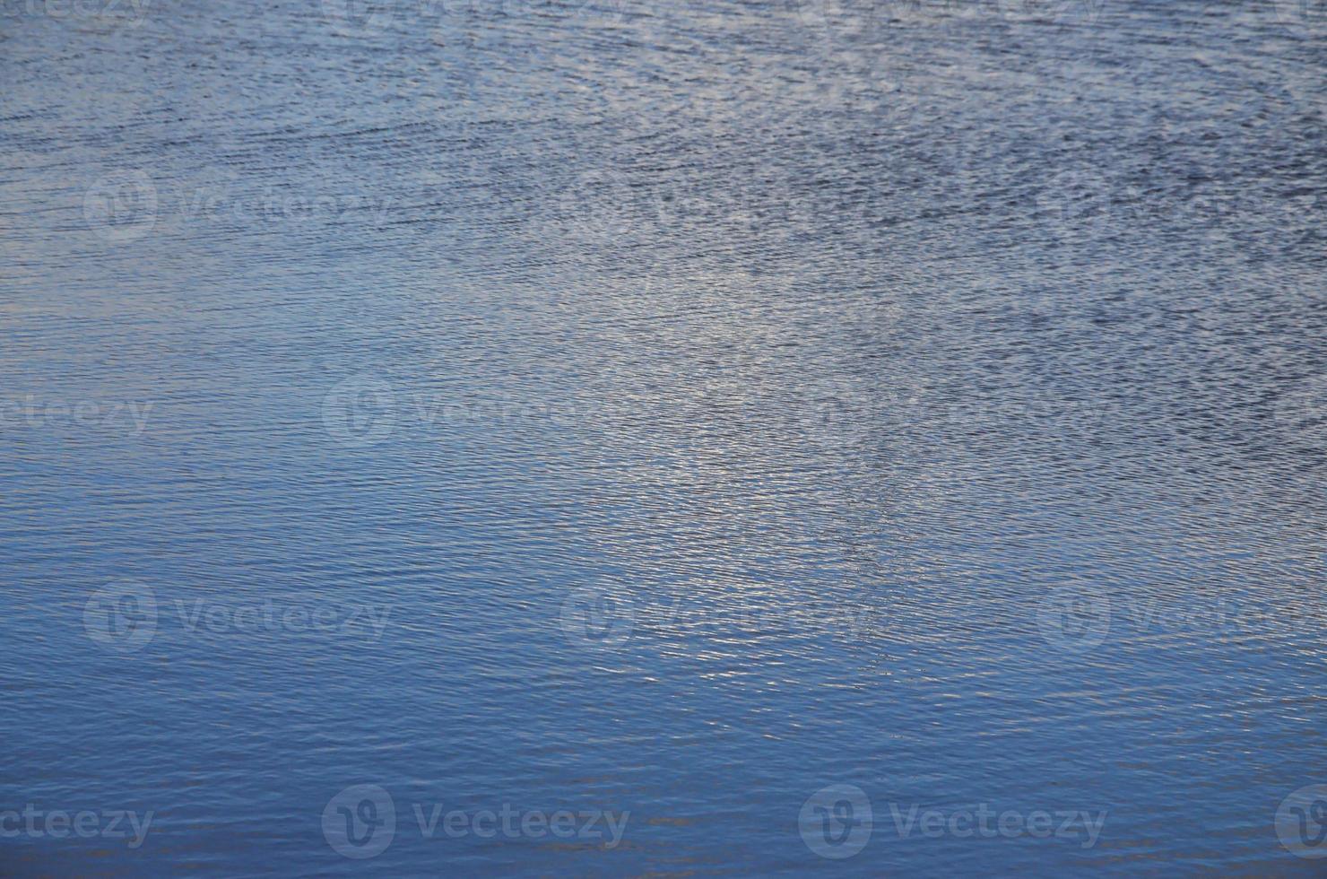 The texture of dark river water under the influence of wind, imprinted in perspective. Horizontal image photo