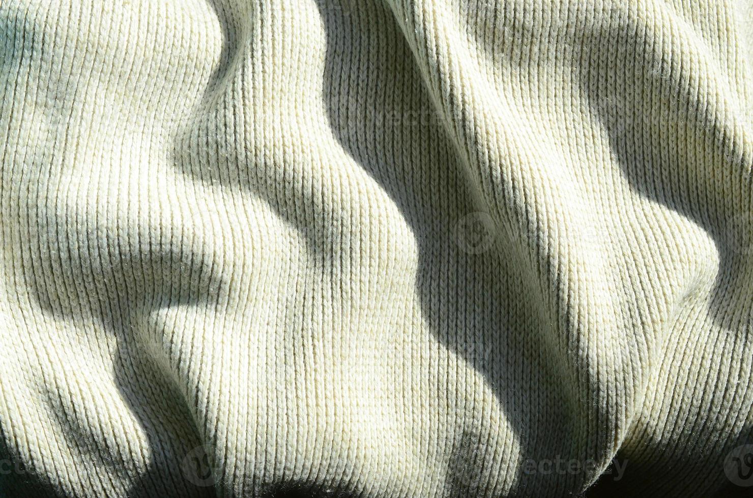 Fabric texture of a soft yellow knitted sweater. Macro image of the structure of bindings in yarns photo