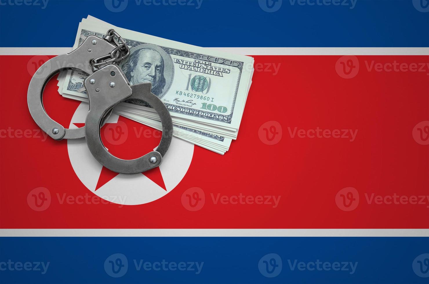 North Korea flag  with handcuffs and a bundle of dollars. The concept of breaking the law and thieves crimes photo