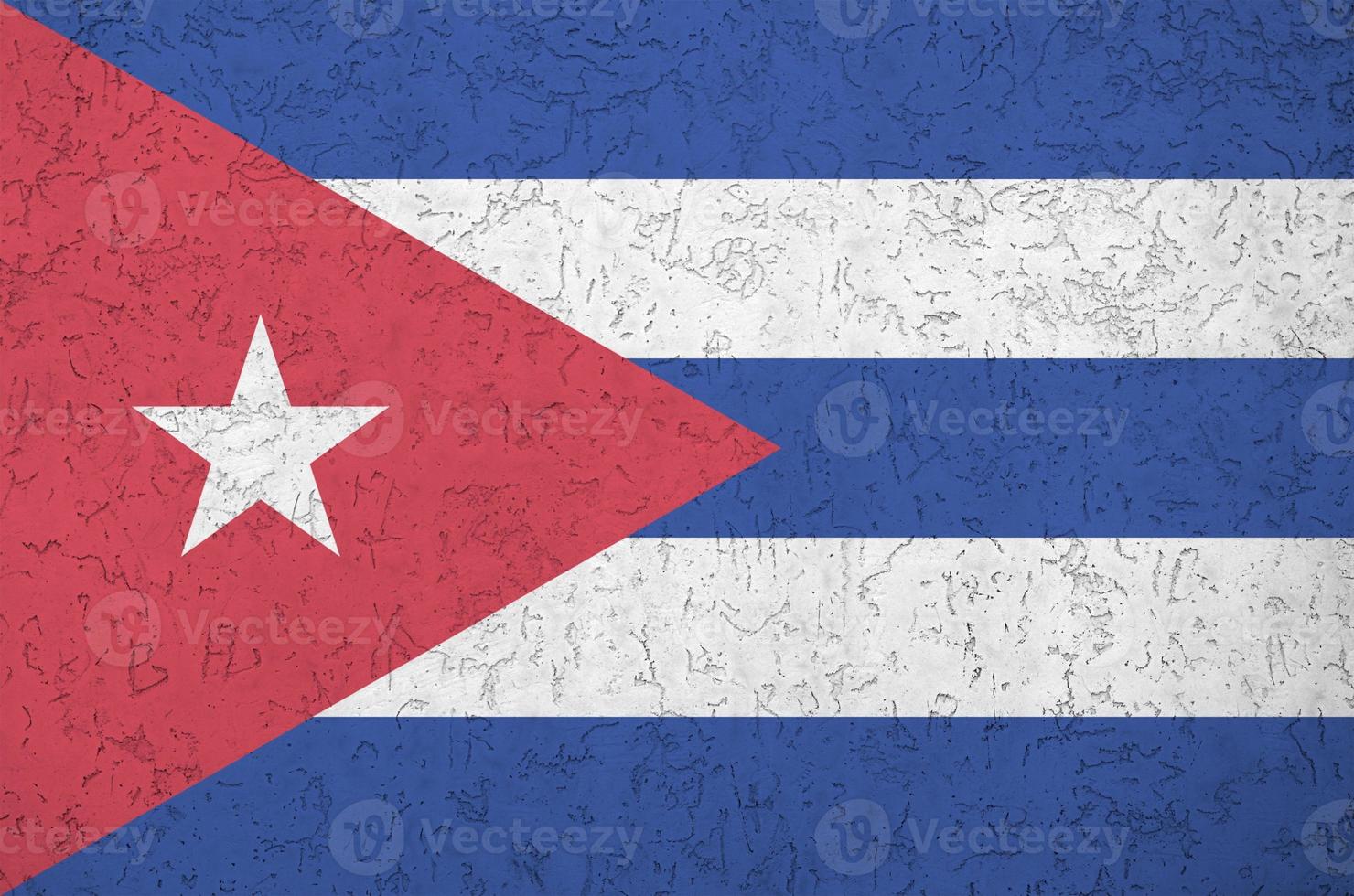 Cuba flag depicted in bright paint colors on old relief plastering wall. Textured banner on rough background photo