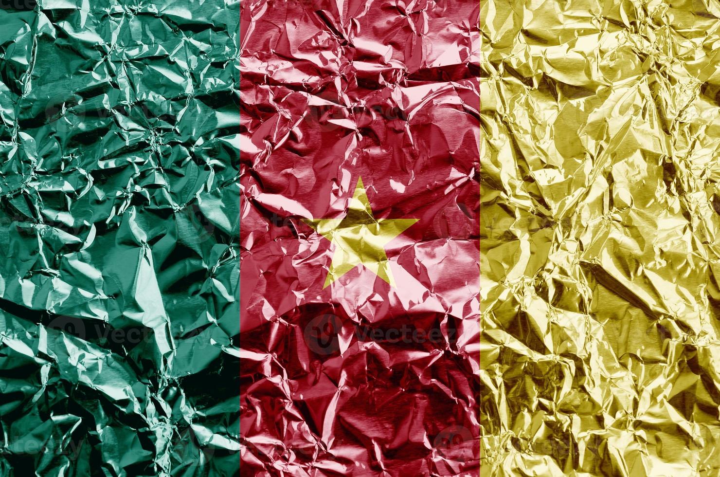 Cameroon flag depicted in paint colors on shiny crumpled aluminium foil closeup. Textured banner on rough background photo