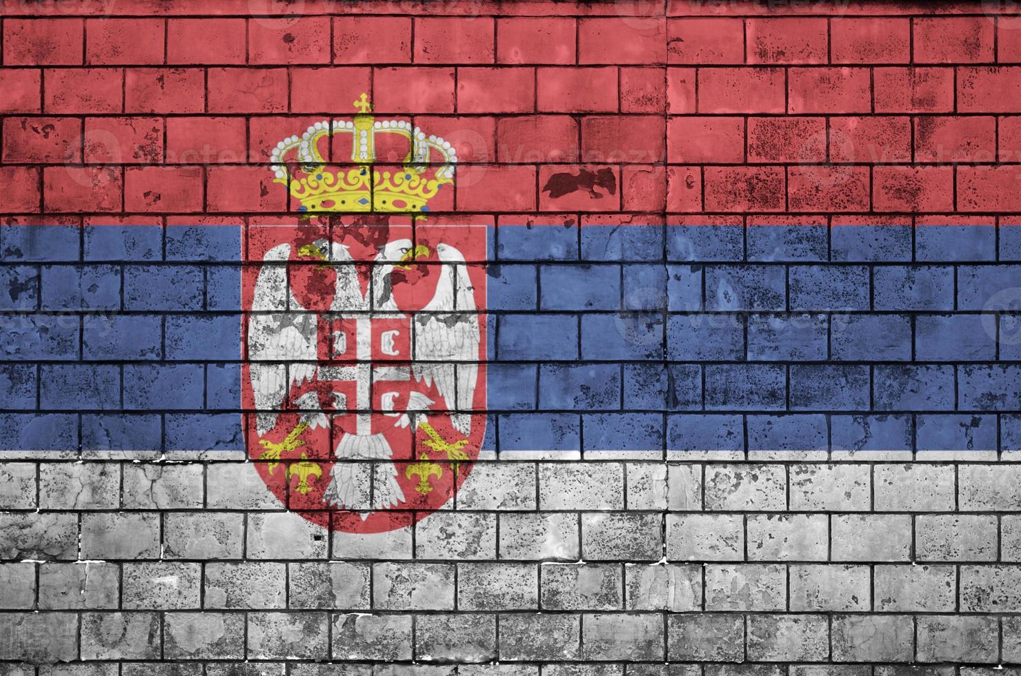 Serbia flag is painted onto an old brick wall photo