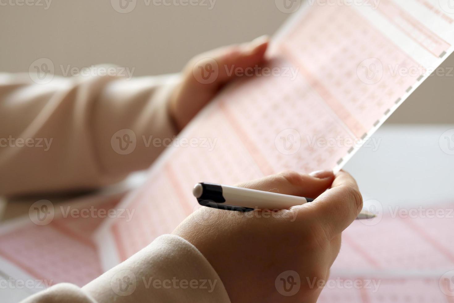 Filling out a lottery ticket. A young woman plays the lottery and dreams of winning the jackpot photo