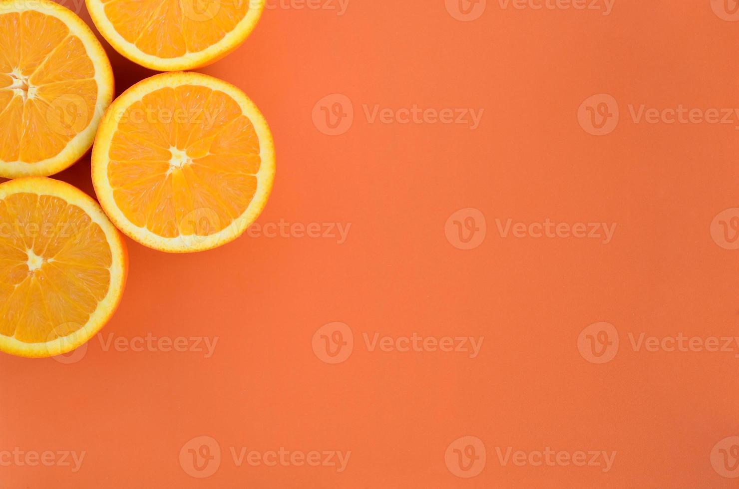 Top view of a several orange fruit slices on bright background in orange color. A saturated citrus texture image photo