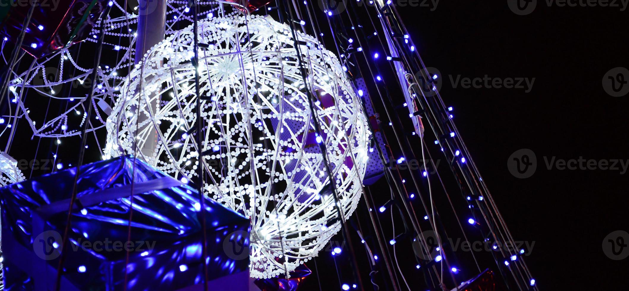 Fragment of the New Year tree. A lot of round lights of blue color are located on a conical frame photo