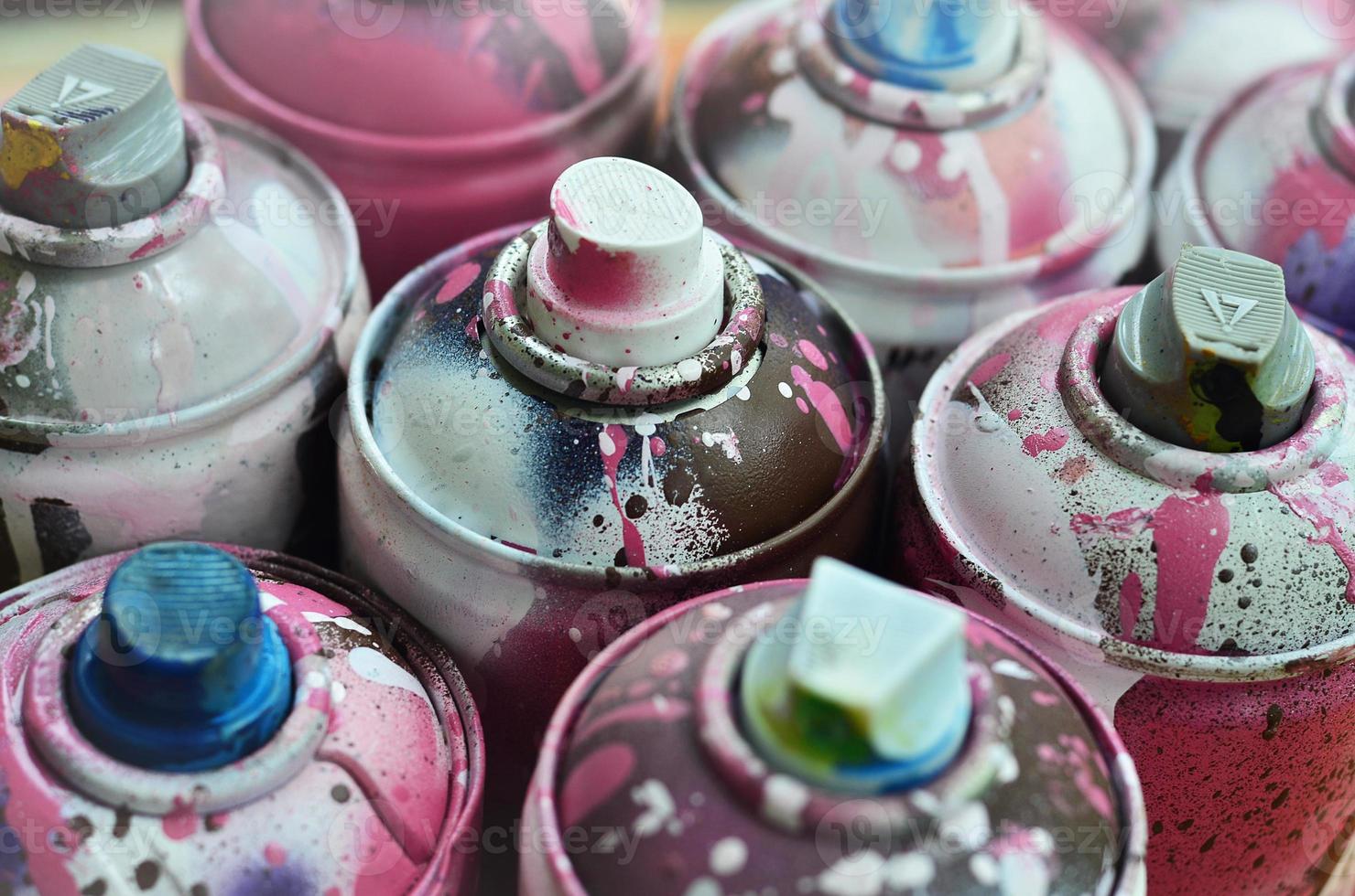 A lot of used spray cans of paint close-up. Dirty and smeared cans for drawing graffiti. The concept of a sweeping and careless drawing of paint. Creative art image photo