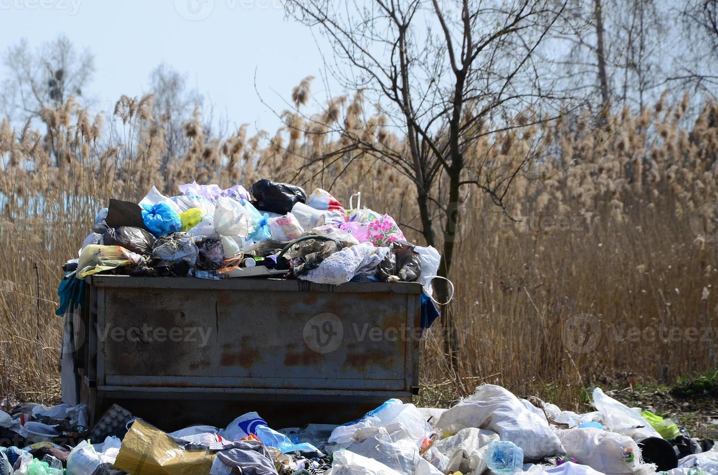 The garbage can is packed with garbage and waste. Untimely removal of garbage in populated areas photo
