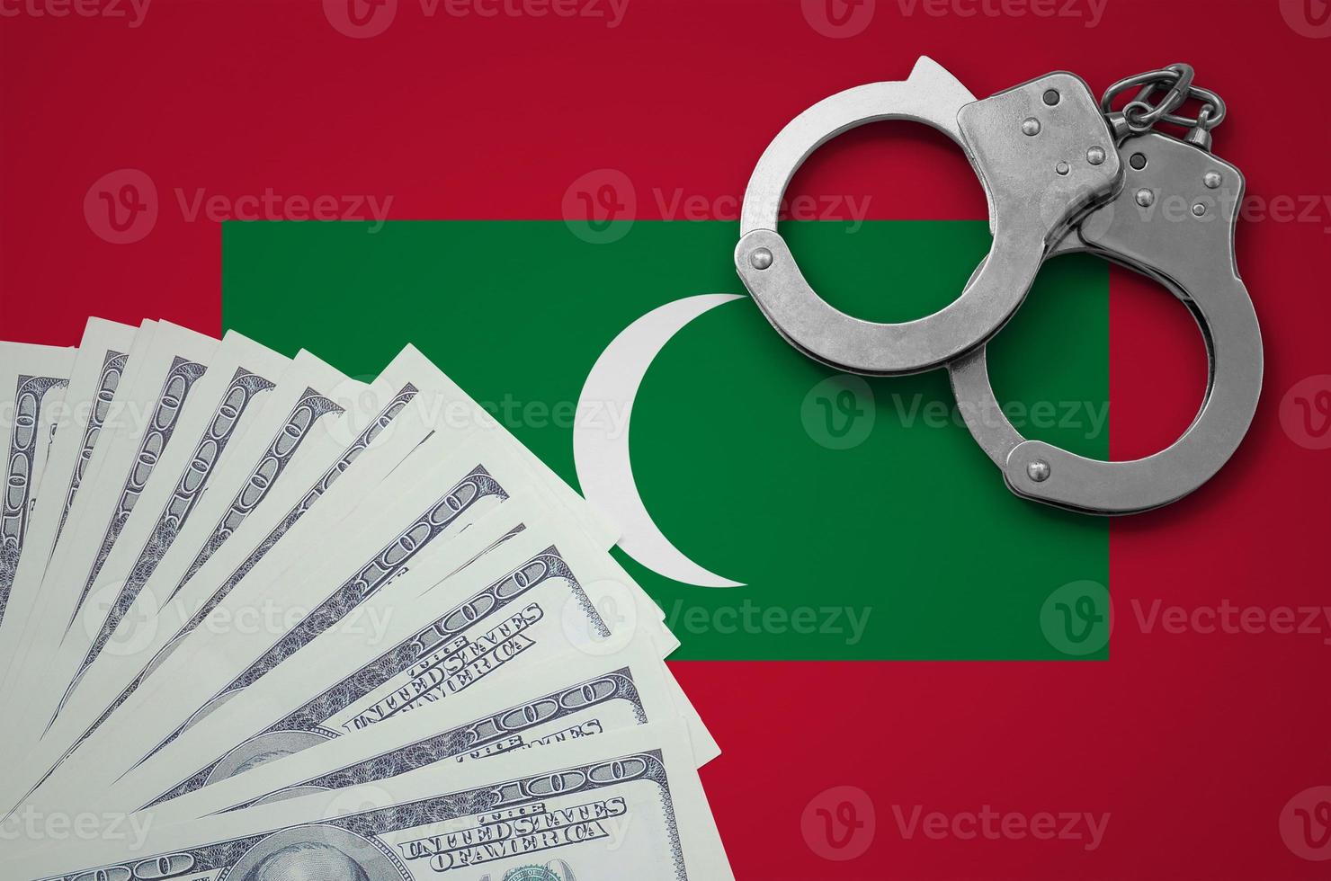 Maldives flag  with handcuffs and a bundle of dollars. The concept of illegal banking operations in US currency photo